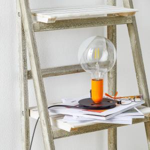 FLOS Lampadina LED da tavolo arancione, base nera